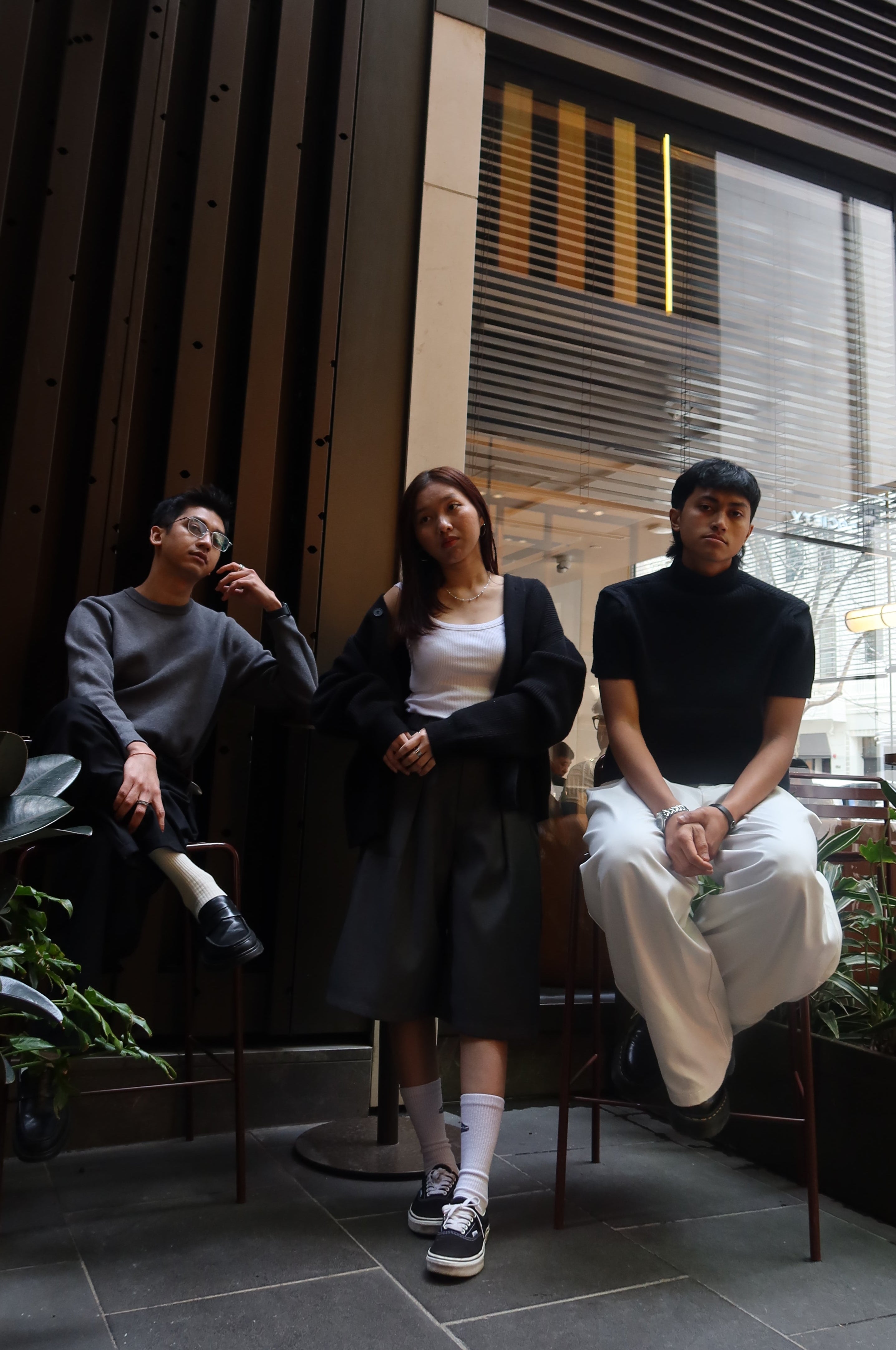 Three people standing on a staircase with a cityscape background
